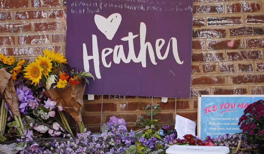 Flowers and signs decorated the site of a memorial to Heather Heyer who died during the Unite the Right rally in 2017 in Charlottesville, Va., Monday, Aug. 12, 2019. (AP Photo/Steve Helber)