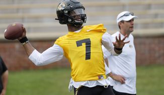 Missouri quarterback Kelly Bryant (7) throws as offensive coordinator Derek Dooley, right, stands off to the side during an NCAA college football practice Monday, Aug. 12, 2019, in Columbia, Mo. (AP Photo/Jeff Roberson)