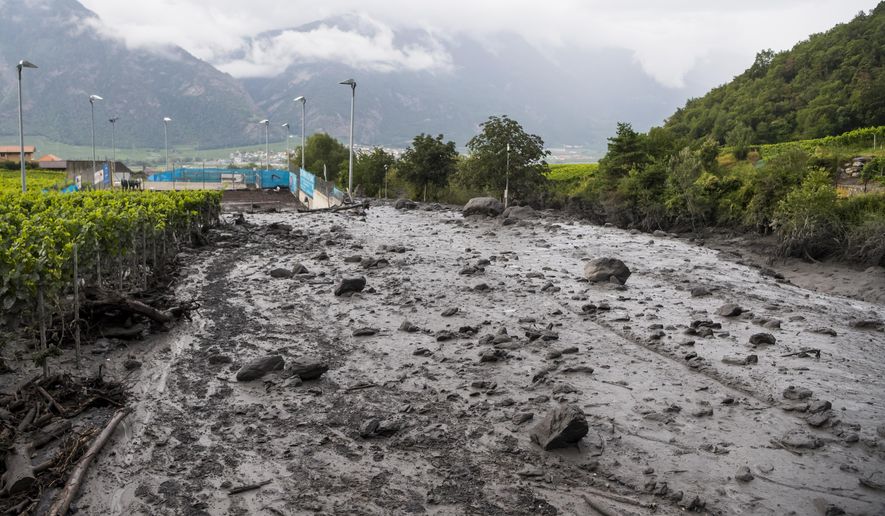 A view of the damage on the banks of the Losentse river on Monday, Aug.12, 2019 in Chamoson, canton Valais, Switzerland. The search continues Monday morning in Chamoson, after the violent storm that struck on Sunday evening. Two people are still missing, carried away in their cars by a mudslide. (Jean-Christophe Bott/Keystone via AP)