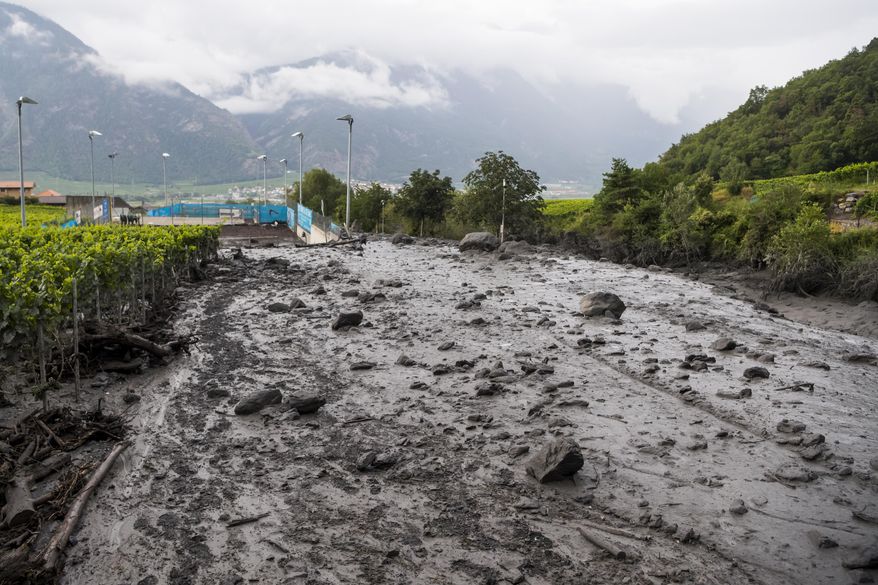 A view of the damage on the banks of the Losentse river on Monday, Aug.12, 2019 in Chamoson, canton Valais, Switzerland. The search continues Monday morning in Chamoson, after the violent storm that struck on Sunday evening. Two people are still missing, carried away in their cars by a mudslide. (Jean-Christophe Bott/Keystone via AP)
