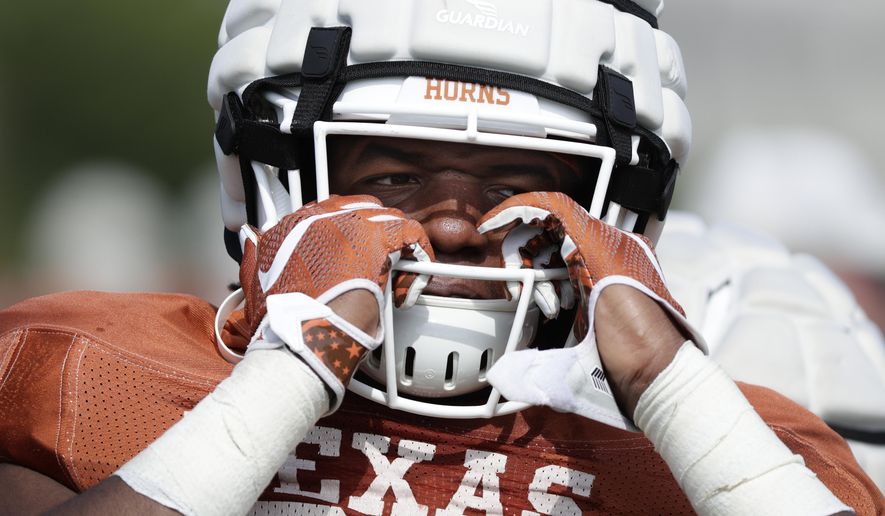 Texas running back Keaontay Ingram adjusts his helmet during a morning practice at the team&#39;s facility in Austin, Texas, Wednesday, Aug. 7, 2019. (AP Photo/Eric Gay)