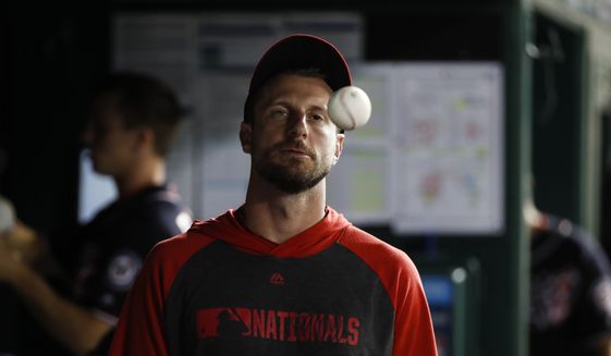 Washington Nationals starting pitcher Max Scherzer tosses a ball in the dugout during a baseball game against the Cincinnati Reds at Nationals Park, Monday, Aug. 12, 2019, in Washington. The Nationals won 7-6. (AP Photo/Alex Brandon)