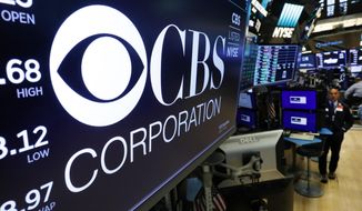 The logo for the CBS Corporation appears above a trading post on the floor of the New York Stock Exchange, Tuesday, Aug. 13, 2019. CBS and Viacom said Tuesday they will reunite, bringing together their networks and the Paramount movie studio as traditional media giants bulk up to challenge streaming companies like Netflix. (AP Photo/Richard Drew)
