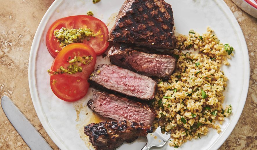 This 2019 photo shows grilled marinated New York Strip Steak in New York. Marinating is a terrific basic kitchen technique. Essentially, you can take any kind of meat, fish or seafood, submerge it in a marinade, and you've turned a plain something into a great dinner. (Cheyenne Cohen/Katie Workman via AP)