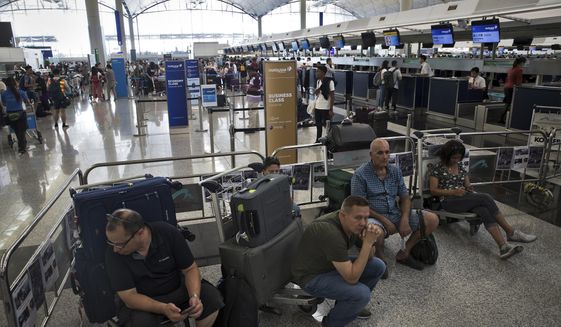 Travelers wait at the check-in counters in the departure hall of the Hong Kong International Airport in Hong Kong, Tuesday, Aug. 13, 2019. Protesters clogged the departure area at Hong Kong&#39;s reopened airport Tuesday, a day after they forced one of the world&#39;s busiest transport hubs to shut down entirely amid their calls for an independent inquiry into alleged police abuse. (AP Photo/Vincent Thian)