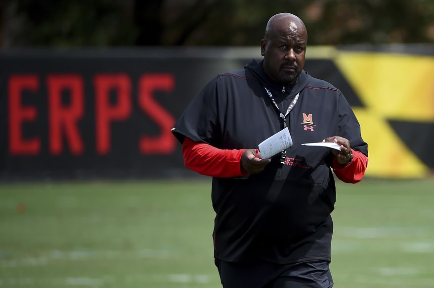In this Aug. 2, 2019, file photo, Maryland head coach Mike Locksley looks on as his team works out during a NCAA college football training camp in College Park, Md. Coming off the darkest season in the history of the Maryland football program, the Terrapins are poised to enter a new era under Mike Locksley, hired in December after a successful run as Alabama's offensive coordinator, who remembers what it was like when the team competed for conference titles and counted on playing in bowl games. (AP Photo/Will Newton, File) **FILE**