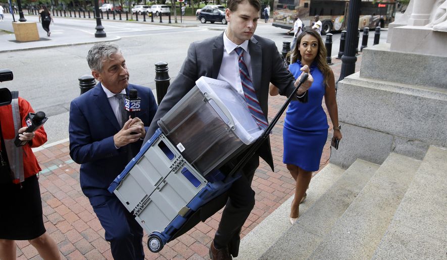 Nathan Carman, center, carries documents as he arrives at federal court, Tuesday, Aug. 13, 2019, in Providence, R.I.  Carman faces civil charges in federal court over insurance issues regarding the boat aboard which he and his mother went out to sea for a night of fishing in 2016. The boat sank, Carman survived but his mother was never found. (AP Photo/Steven Senne)