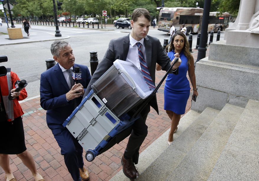 Nathan Carman, center, carries documents as he arrives at federal court, Tuesday, Aug. 13, 2019, in Providence, R.I. Carman faces civil charges in federal court over insurance issues regarding the boat aboard which he and his mother went out to sea for a night of fishing in 2016. The boat sank, Carman survived but his mother was never found. (AP Photo/Steven Senne)