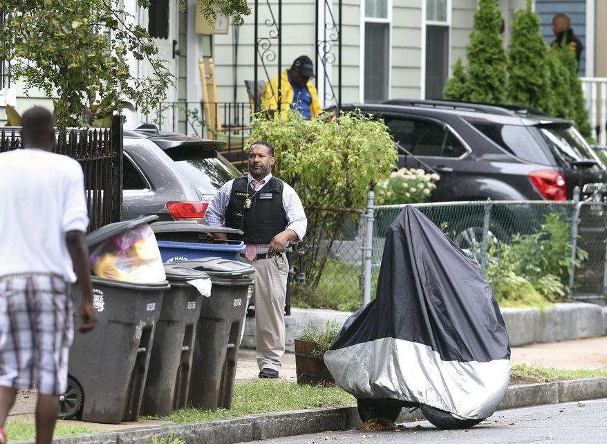 New Haven police walk door-to-door on Orchard Street in New Haven on Tuesday, August 13, 2019 near where New Haven Police Captain Anthony Duff was shot Monday night responding to a shooting while off-duty. He is hospitalized in stable condition after being shot and police are hunting for a suspect who investigators say also fatally shot another man. Arnold Gold/Hearst Connecticut Media via AP)