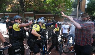 In this June 29, 2019, photo, after a confrontation between authorities and protesters, police use pepper spray as multiple groups, including Rose City Antifa, the Proud Boys and others protest in downtown Portland, Ore. Portland police are mobilizing in hopes of avoiding clashes between out-of-state hate groups planning a rally Saturday, Aug. 17, 2019, and homegrown anti-fascists who say they’ll come out to oppose them. (Dave Killen/The Oregonian via AP) **FILE**