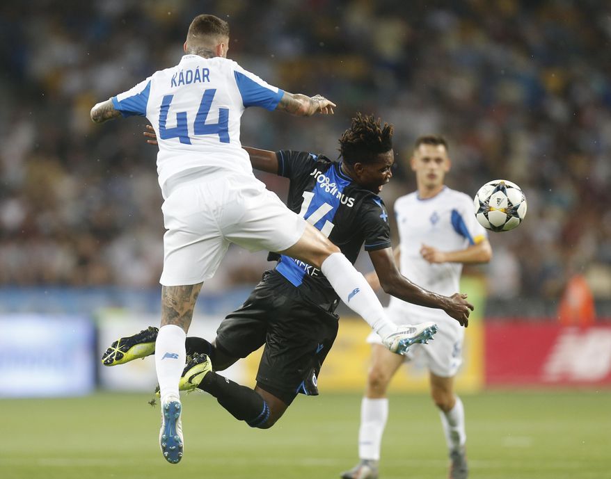 Brugge's David Okereke, right, and Dynamo Kiev's Tamas Kadar challenge for the ball during the Champions League third qualifying round, second leg, soccer match between Dynamo Kyiv and Club Brugge at the Olympiyskiy stadium in Kiev, Ukraine, Tuesday, Aug. 13, 2019. (AP Photo/Efrem Lukatsky)