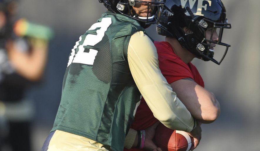 Wake Forest quarterback Jamie Newman takes a snap during the first day of NCAA college football practice in Winston-Salem, N.C., Thursday, Aug. 1, 2019. (Walt Unks/Winston-Salem Journal via AP)