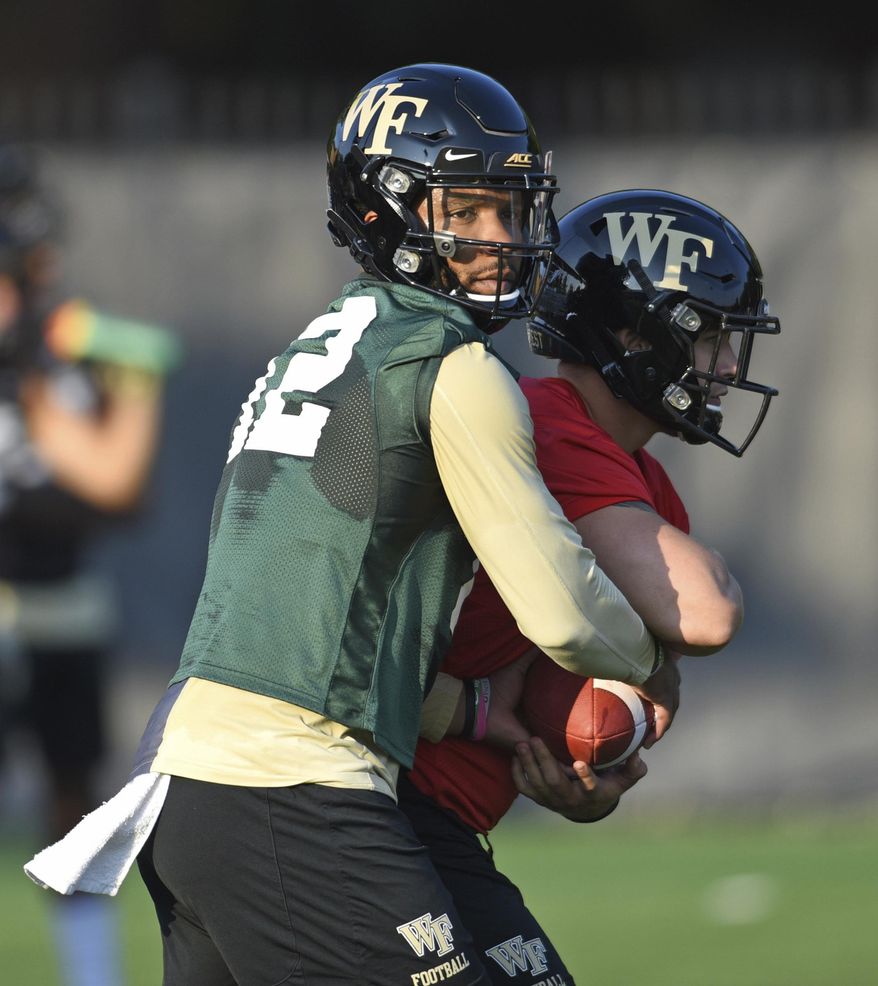 Wake Forest quarterback Jamie Newman takes a snap during the first day of NCAA college football practice in Winston-Salem, N.C., Thursday, Aug. 1, 2019. (Walt Unks/Winston-Salem Journal via AP)