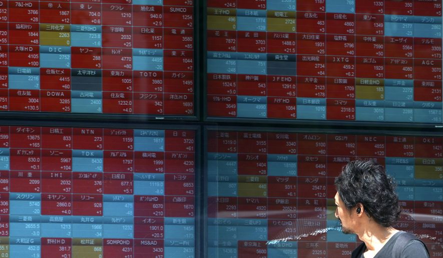 In this Aug. 9, 2019, photo, a man looks at an electronic stock board showing Japan's Nikkei 225 index at a securities firm in Tokyo. Asian shares were mostly higher Wednesday, Aug. 14, 2019 after the U.S. said it would hold off on tariffs of Chinese imports of mobile phones, toys and several other items typically on holiday shopping lists. (AP Photo/Eugene Hoshiko)