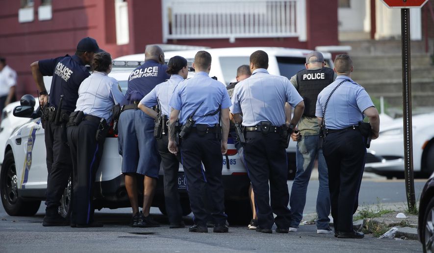Philadelphia police stage as they respond to an active shooting situation, Wednesday, Aug. 14, 2019, in the Nicetown neighborhood of Philadelphia. (AP Photo/Matt Rourke)
