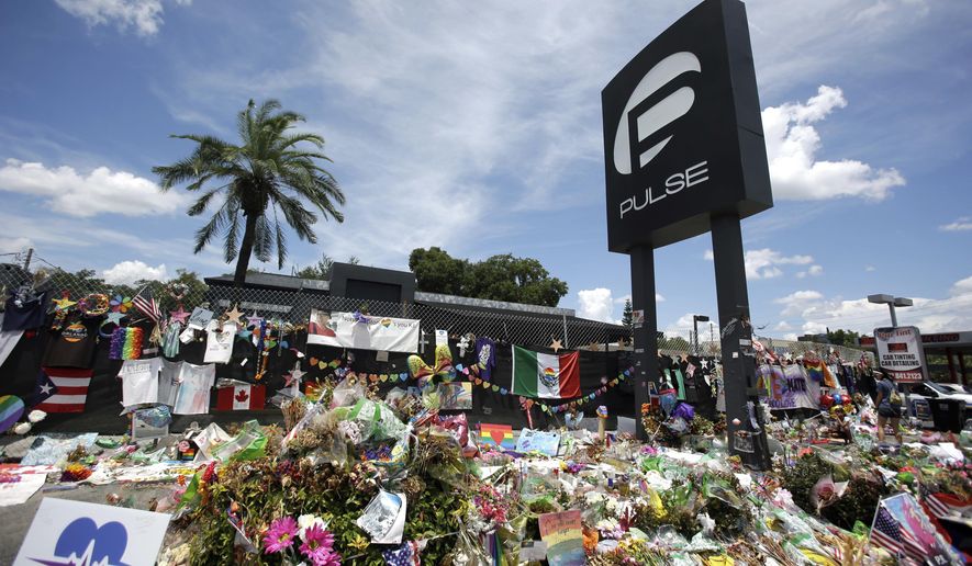 In this July 11, 2016, file photo, a makeshift memorial continues to grow outside the Pulse nightclub in Orlando, the day before the one month anniversary of a mass shooting, in Orlando, Fla. A group of survivors and family members of those killed have formed an organization to oppose the building of a private museum to honor the victims of a mass shooting at the Florida nightclub three years ago. Members of the Community Coalition Against a Pulse Museum say the nightclub should be torn down and the nightclub's owner shouldn't build a private museum. (AP Photo/John Raoux, File)