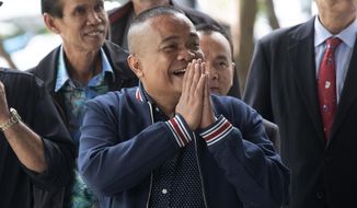 Jatuporn Phromphan, center, one of the leaders of Red Shirt, arrives at the Bangkok Criminal Court in Bangkok, Thailand, Wednesday, Aug. 14, 2019. The court has dismissed charges of terrorism and other offenses against 24 leaders of an extended street protest in 2010 that saw key parts of central Bangkok closed off and random violence that was ended by armed military force. (AP Photo/Sakchai Lalit)