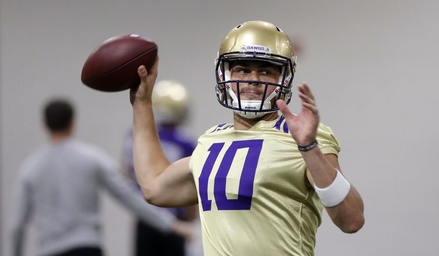 FILE - In this Aug. 5, 2019, file photo, Washington quarterback Jacob Eason readies a throw during an NCAA football practice in Seattle. In his tenure at Washington, Chris Petersen has faced situations where the Huskies lose a significant chunk of talent to the next level, only to replenish and continue what’s been an upward trend during his first five seasons in charge. This season will test whether the Huskies can simply continue to reloadThey could have Georgia transfer Jacob Eason _ once the top recruit in the country coming out of high school _ under center at quarterback. (AP Photo/Elaine Thompson, File)