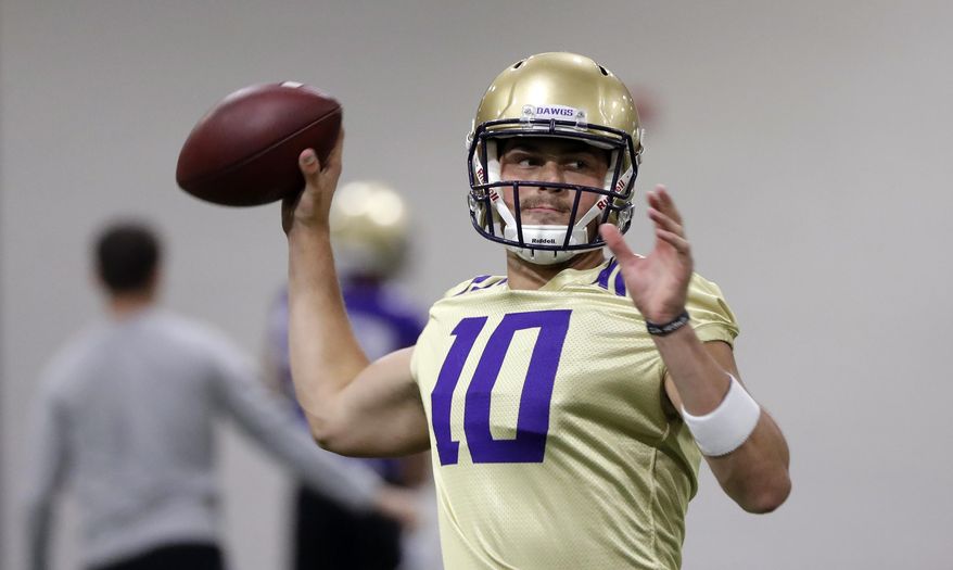 FILE - In this Aug. 5, 2019, file photo, Washington quarterback Jacob Eason readies a throw during an NCAA football practice in Seattle. In his tenure at Washington, Chris Petersen has faced situations where the Huskies lose a significant chunk of talent to the next level, only to replenish and continue what’s been an upward trend during his first five seasons in charge. This season will test whether the Huskies can simply continue to reloadThey could have Georgia transfer Jacob Eason _ once the top recruit in the country coming out of high school _ under center at quarterback. (AP Photo/Elaine Thompson, File)
