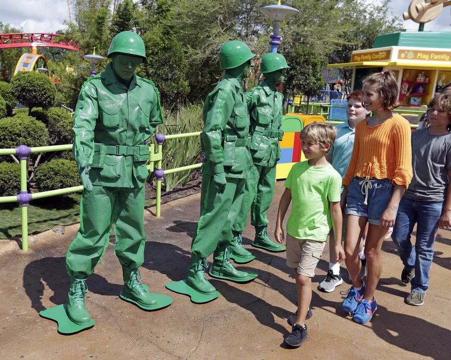 In this Saturday, June 23, 2018 photo, Green Army men interact with guests at Toy Story Land in Disney&#x27;s Hollywood Studios at Walt Disney World in Lake Buena Vista, Fla. (AP Photo/John Raoux)