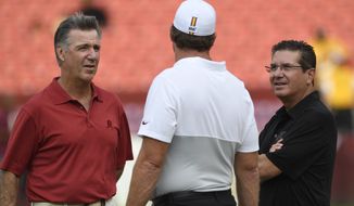 Washington Redskins team owner Dan Snyder, right, and Washington Redskins team president Bruce Allen, left, talk with head coach Jay Gruden, center, before the start of a NFL preseason football game against the Cincinnati Bengals in Landover, Md., Thursday, Aug. 15, 2019. (AP Photo/Susan Walsh)