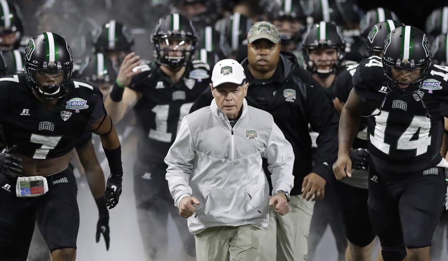 FILE - In this Dec. 2, 2016, file photo, Ohio head coach Frank Solich runs out onto the field with his team before the Mid-American Conference championship NCAA college football game against Western Michigan, in Detroit. Solich is expected to become the Mid-American Conference’s all-time winning coach this season. The former Nebraska coach has won 106 games with the Bobcats over 15 years since Nebraska fired him following a nine-win season. (AP Photo/Carlos Osorio, File)
