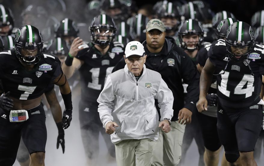 FILE - In this Dec. 2, 2016, file photo, Ohio head coach Frank Solich runs out onto the field with his team before the Mid-American Conference championship NCAA college football game against Western Michigan, in Detroit. Solich is expected to become the Mid-American Conference’s all-time winning coach this season. The former Nebraska coach has won 106 games with the Bobcats over 15 years since Nebraska fired him following a nine-win season. (AP Photo/Carlos Osorio, File)