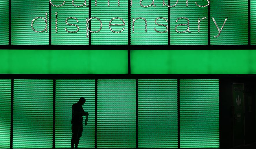 File - In this April 16, 2018, file photo, a man stands outside after shopping at the Essence cannabis dispensary in Las Vegas. Attorneys for dozens of bidders that didn't get retail marijuana dispensary licenses are telling a judge the process was so unfair she should order a do-over and block 61 businesses that got permits from opening. With millions of dollars at stake, Clark County District Court Judge Elizabeth Gonzalez heard closing arguments Thursday, Aug. 15, 2019, from plaintiffs seeking a court injunction after 18 days of testimony over the course of 12 weeks. (AP Photo/John Locher, File)