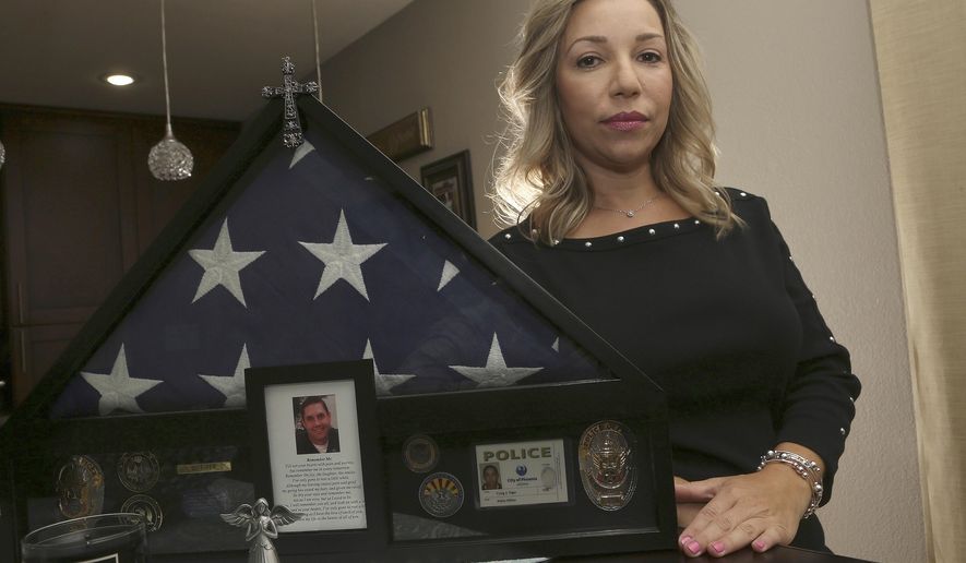 Rebecca Tiger, a former Phoenix police officer, is the widow of Craig Tiger, a Phoenix police officer who committed suicide a few years ago following a fatal shooting he was involved in, shown her home Monday, July 1, 2019, in Scottsdale, Ariz. Officer Craig Tiger suffered from post-traumatic stress disorder after fatally shooting a man while on duty back in 2012, and took his own life two years later. (AP Photo/Ross D. Franklin)