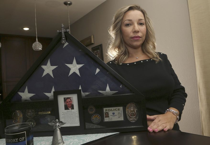 Rebecca Tiger, a former Phoenix police officer, is the widow of Craig Tiger, a Phoenix police officer who committed suicide a few years ago following a fatal shooting he was involved in, shown her home Monday, July 1, 2019, in Scottsdale, Ariz. Officer Craig Tiger suffered from post-traumatic stress disorder after fatally shooting a man while on duty back in 2012, and took his own life two years later. (AP Photo/Ross D. Franklin)