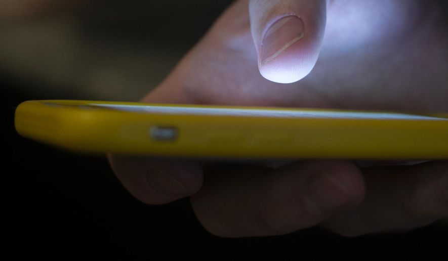 In this Sunday, Aug. 11, 2019, photo, a man uses a cellphone in New Orleans. (AP Photo/Jenny Kane) **FILE**