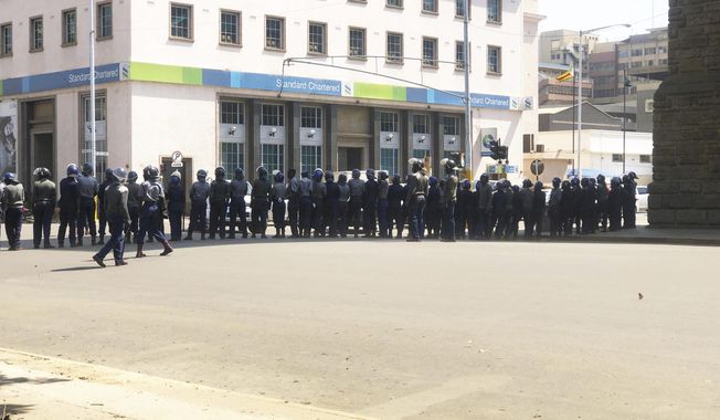 Armed Riot Police block a main road during a patrol on the streets in Harare, Thursday, Aug, 15, 2019.  In a show of force to discourage anti government protests, Zimbabwe police with water cannons patrolled the capital&#x27;s streets and warned residents, &amp;quot;you will rot in jail&amp;quot; if they participated in the demonstrations planned for Friday. (AP Photo/Tsvangirayi Mukwazhi)