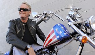 In this Friday, Oct. 23, 2009, file photo, Peter Fonda, poses atop a Harley-Davidson motorcycle in Glendale, Calif. Fonda, the son of a Hollywood legend who became a movie star in his own right both writing and starring in counterculture classics like “Easy Rider,” has died. His family says in a statement that Fonda died Friday, Aug. 16, 2019, at his home in Los Angeles. He was 79. (AP Photo/Chris Pizzello, File)