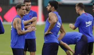 Barcelona&#39;s Philippe Coutinho, left, talks with Luis Suarez, center, during soccer practice Tuesday, Aug. 6, 2019, in Miami Gardens, Fla. FC Barcelona plays SSC Napoli on Wednesday. (AP Photo/Lynne Sladky)