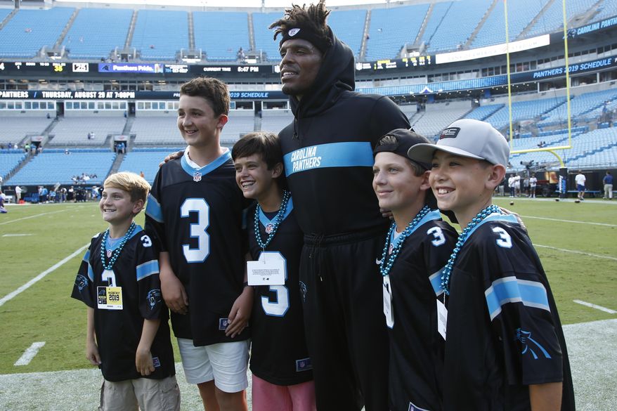 Carolina Panthers quarterback Cam Newton poses with children before the first half an NFL preseason football game against the Buffalo Bills, Friday, Aug. 16, 2019, in Charlotte. (AP Photo/Brian Blanco)