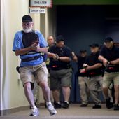 In this July 21, 2019 photo, Stephen Hatherley, left, leads fellow trainees down a hallway as they participate in a simulated gun fight scenario at Fellowship of the Parks campus in Haslet, Texas.  While recent mass shootings occurred at a retail store in El Paso, Texas, and a downtown entertainment district in Dayton, Ohio, they were still felt in houses of worship, which haven’t been immune to such attacks. And some churches have started protecting themselves with guns. (AP Photo/Tony Gutierrez)