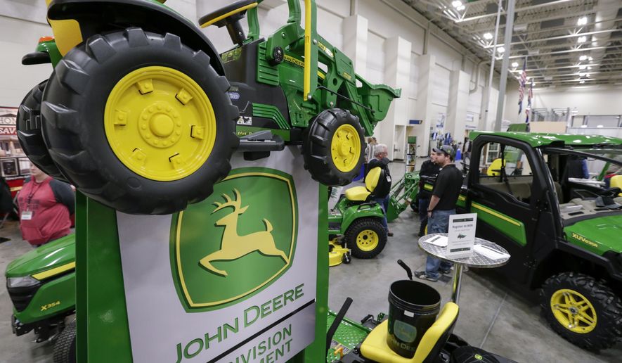 FILE - In this Feb. 23, 2018 file photo, John Deere products, including a toy tractor on the sign, are on display at a home and garden trade show in Council Bluffs, Iowa. John Deere reports financial earnings Friday, Aug. 16, 2019. (AP Photo/Nati Harnik, File)