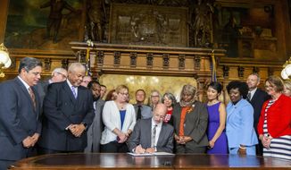 Pa. Gov. Tom Wolf signs executive order to reduce gun violence during a ceremony at the state Capitol on Friday, Aug. 16, 2019 in Harrisburg, Pa.   Watching are, from left, Senate Democratic Leader Jay Costa, Allegheny County, Sen. Tony Williams, D-Philadelphia, Rep. Jordan Harris, D-Philadelphia, Shira Goodman, CeaseFire Pa., Rep. Movita Johnson-Harrell, D-Philadelphia, Patty Kim, D-Dauphin County, Rep. Joanna McClinton, D-Philadelphia and Rep. Maureen Madden, D-Monroe County.  (Joe Hermitt/The Patriot-News via AP)