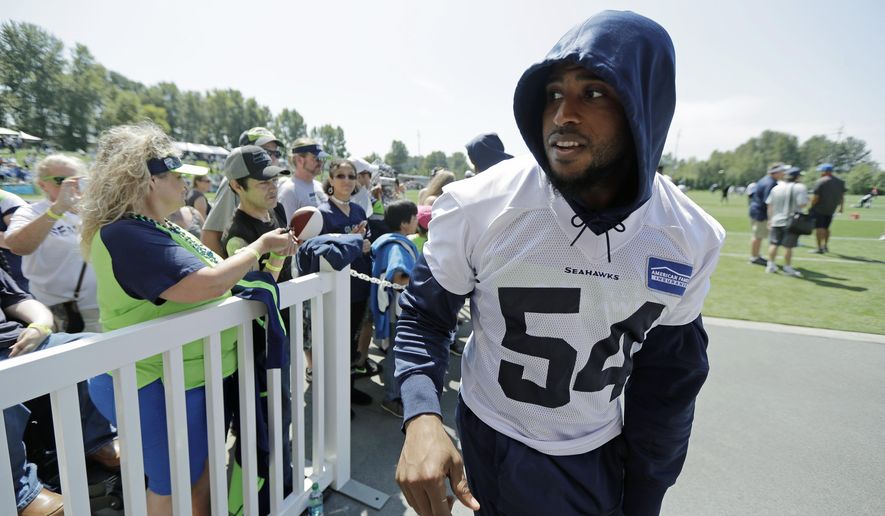 Seattle Seahawks linebacker Bobby Wagner heads to the locker room after giving autographs following NFL football training camp, Monday, Aug. 5, 2019, in Renton, Wash. (AP Photo/Ted S. Warren)