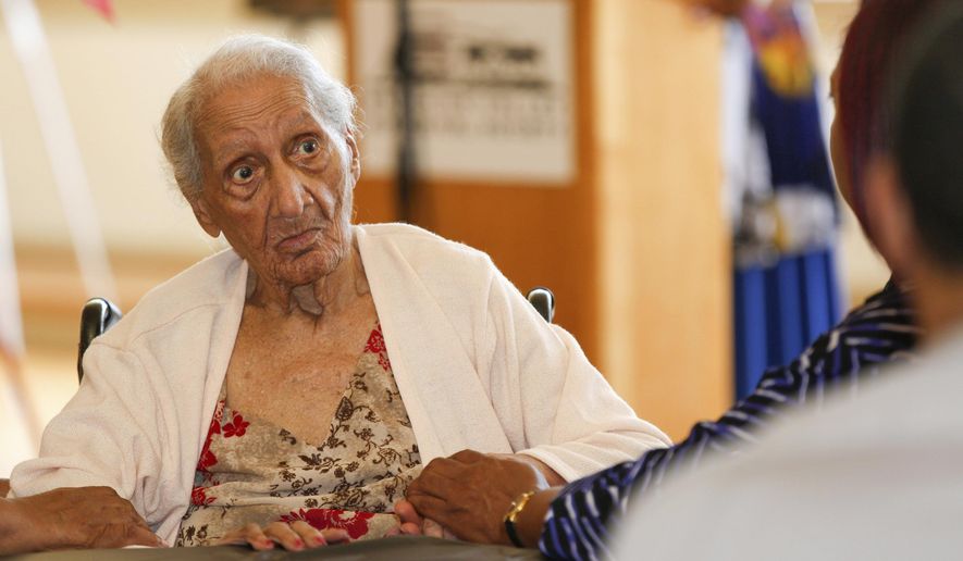 Valentina Williams, who will turn 110 on August 23, sits with her family during an event to honor four of the Mahoning Valley's oldest black residents, including Williams, at the Tyler History Center in Youngstown, Ohio Sunday, Aug. 11, 2019. She's lived through two world wars, seen the development of the automobile industry and the space program. She's seen world leaders rise and fall, and she's lived through the administrations of nearly 20 U.S. presidents. (Emily Matthews/The Vindicator via AP)