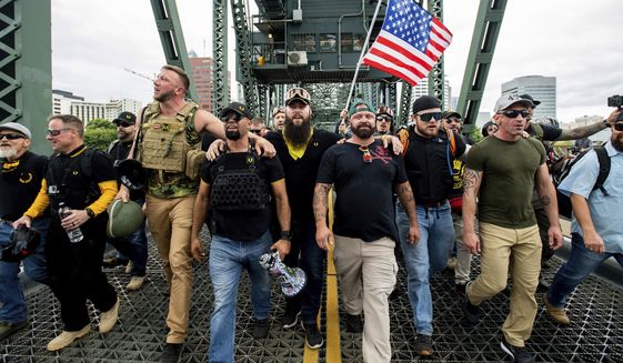 Members of the Proud Boys and other right-wing demonstrators march across the Hawthorne Bridge during an &amp;quot;End Domestic Terrorism&amp;quot; rally in Portland, Ore., on Saturday, Aug. 17, 2019. The group includes organizer Joe Biggs, in a green hat, and Proud Boys Chairman Enrique Tarrio, holding megaphone. (AP Photo/Noah Berger) ** FILE **