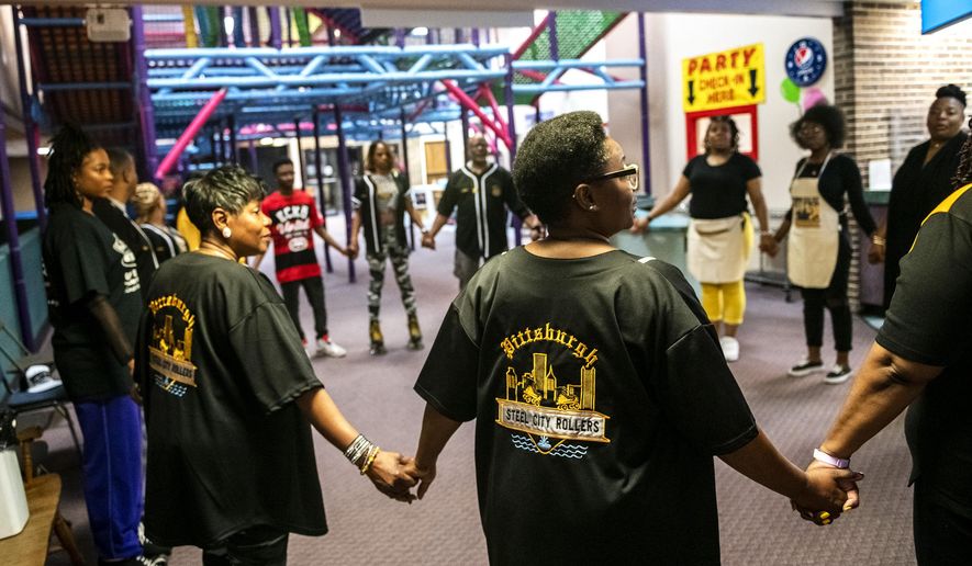In this Saturday, May 18, 2019 photo, members of the Pittsburgh Steel City Rollers hold hands and pray before the start of their annual Spring Bling Skate Jam, at Youngstown Skates in Youngstown, Ohio. The annual skate jam attracts skaters from various parts of the country. (Michael M. Santiago/Pittsburgh Post-Gazette via AP)