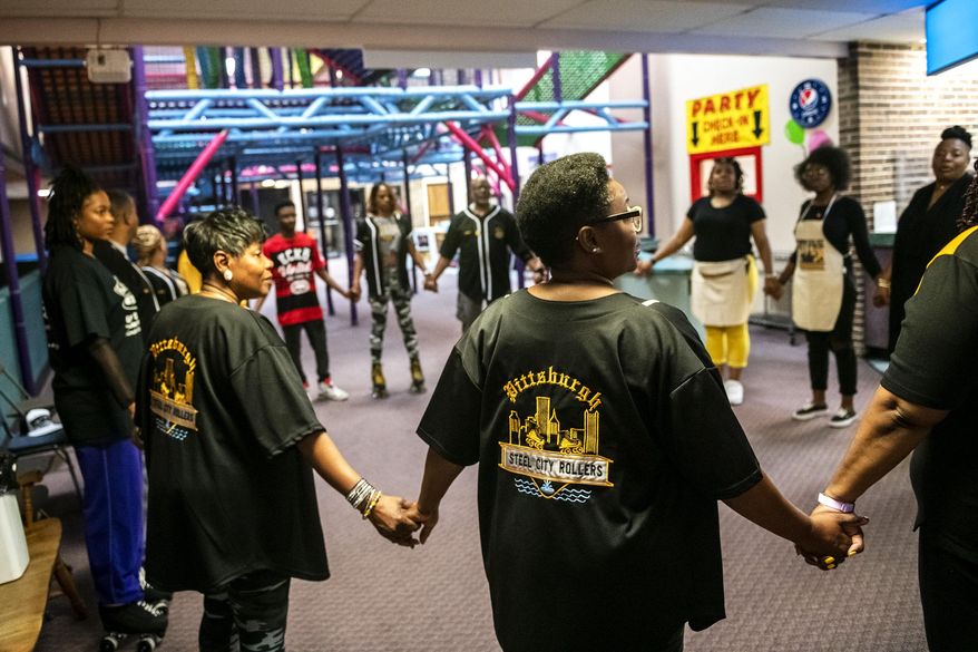 In this Saturday, May 18, 2019 photo, members of the Pittsburgh Steel City Rollers hold hands and pray before the start of their annual Spring Bling Skate Jam, at Youngstown Skates in Youngstown, Ohio. The annual skate jam attracts skaters from various parts of the country. (Michael M. Santiago/Pittsburgh Post-Gazette via AP)
