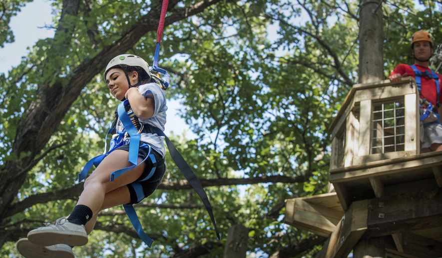In this Aug. 8, 2019 photo, Girl Scout Mataya Wilcox leaps from 30 feet on a QuickFlight free fall device at Eugene's Adventure Course, named for the late Girl Scouts Spirit of Nebraska benefactor and outdoor enthusiast Eugene Catron, near Nebraska City, Neb. (Francis Gardler/Lincoln Journal Star via AP)