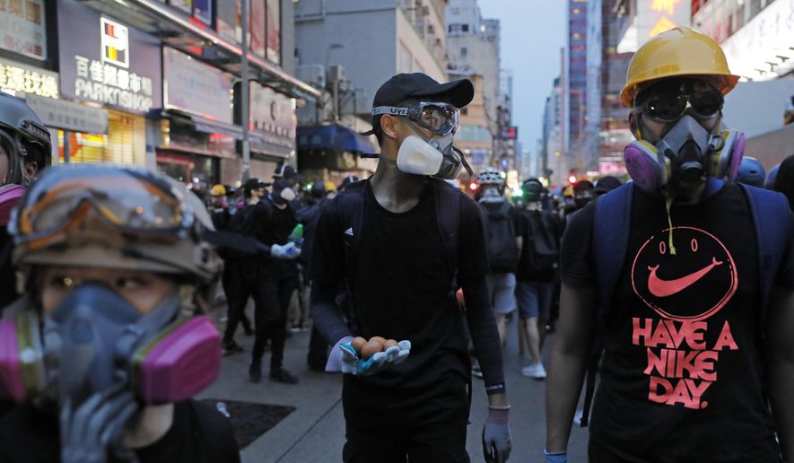 A pro-democracy protester holds eggs as he plan to throw them to the police station during a protest march in Hong Kong Saturday, Aug. 17, 2019. Another weekend of protests is underway in Hong Kong as Mainland Chinese police are holding drills in nearby Shenzhen, prompting speculation they could be sent in to suppress the protests. (AP Photo/Kin Cheung)