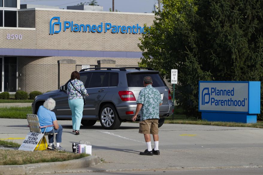 Abortion protesters attempt to hand out literature as they stand in the driveway of a Planned Parenthood clinic in Indianapolis, Ind., in this Friday, Aug. 16, 2019 file photo. (AP Photo/Michael Conroy) **FILE**