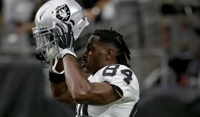 Oakland Raiders wide receiver Antonio Brown (84) puts on his helmet prior to an NFL football game against the Arizona Cardinals, Thursday, Aug. 15, 2019, in Glendale, Ariz. (AP Photo/Rick Scuteri)