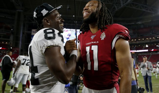 Oakland Raiders wide receiver Antonio Brown (84) and Arizona Cardinals wide receiver Larry Fitzgerald (11) meet at midfield after an an NFL preseason football game, Thursday, Aug. 15, 2019, in Glendale, Ariz. The Raiders won 33-26. (AP Photo/Rick Scuteri)