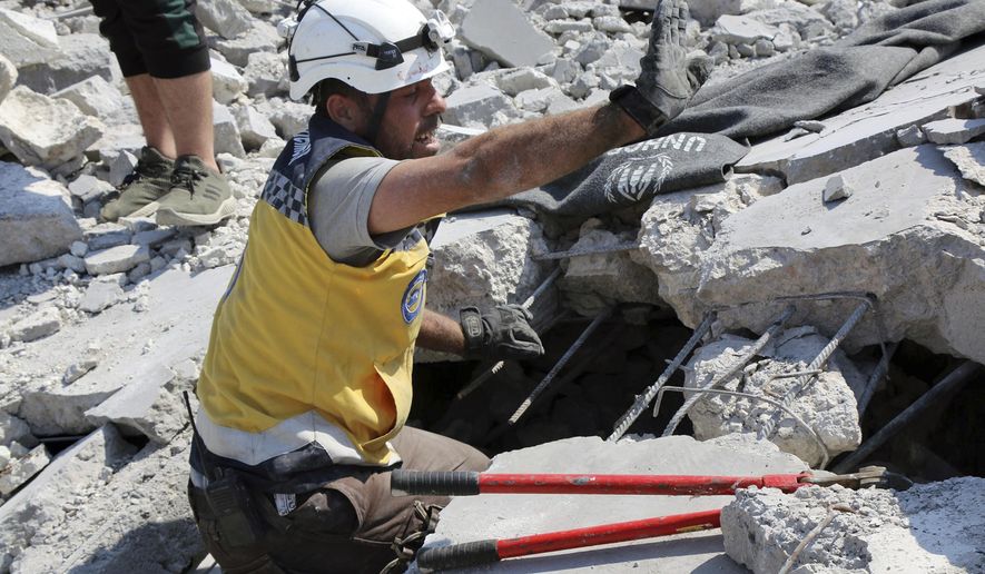 This photo provided by the Syrian Civil Defense White Helmets, which has been authenticated based on its contents and other AP reporting, shows a Civil Defense worker searching for victims from under the rubble of a destroyed building that hit by airstrikes, in Deir al-Sharqi village, in Idlib province, Syria, Saturday, Aug 17, 2019. Syrian activists and a war monitor say airstrikes have pounded the southern edge of a rebel stronghold in the country's northwest, in one instance killing seven including children. (Syrian Civil Defense White Helmets via AP)