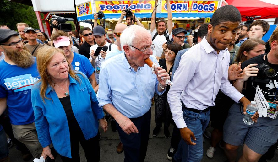 Presidential candidate Sen. Bernard Sanders eats a corn dog with his wife, Jane, (left) at Iowa State Fair in Des Moines, Iowa. (ASSOCIATED PRESS)